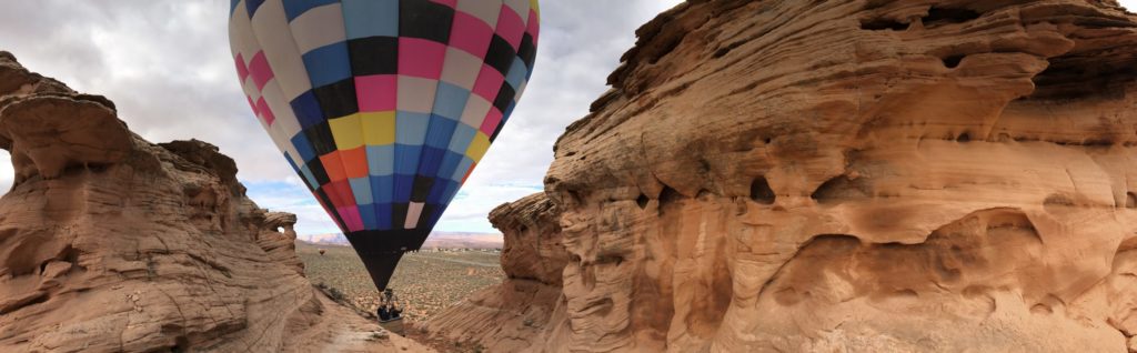 One of Apex Balloons' hot air balloons lands on a sandstone rock formation in Page, Arizona.